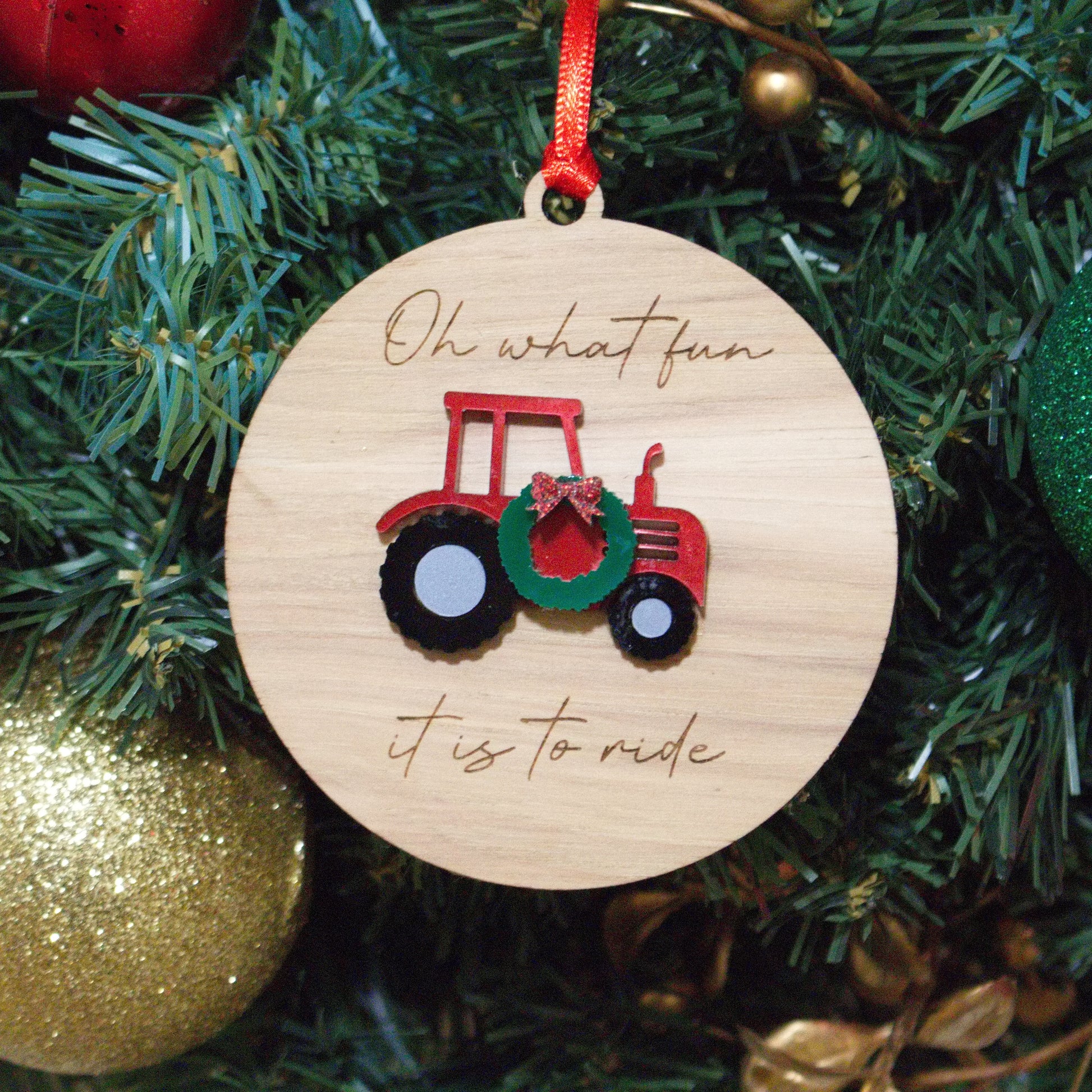 Oh What Fun It Is To Ride Christmas ornament with a tractor and a wreath hanging on it.